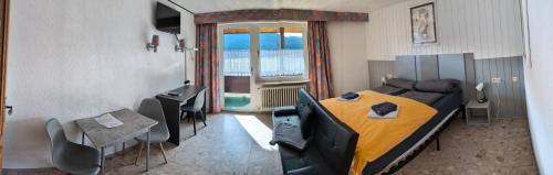 una camera con letto, tavolo e sedie di Hotel Sonnenmatte Titisee B und B nahe Badeparadies a Titisee