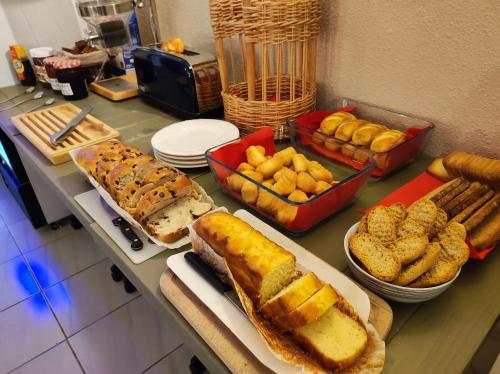 a table topped with different types of bread and pastries at Hôtel et Appart'Hôtel Le Relais Du Val D'Orbieu in Ornaisons