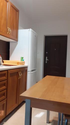 a kitchen with a white refrigerator and a table at Energy House in Jasło