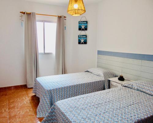 - une chambre avec 2 lits et un lustre dans l'établissement Playa Chica House 2 Fuerteventura, à Puerto del Rosario