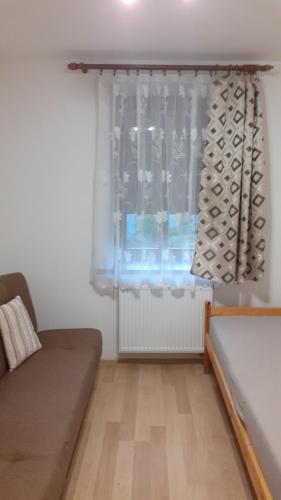 a living room with a couch and a window at Energy House in Jasło