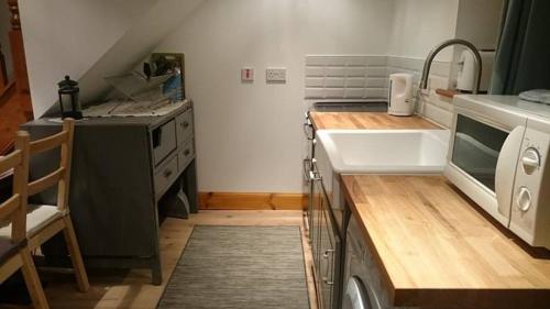 a kitchen with a sink and a washing machine at Kildonan cottage in Johnshaven