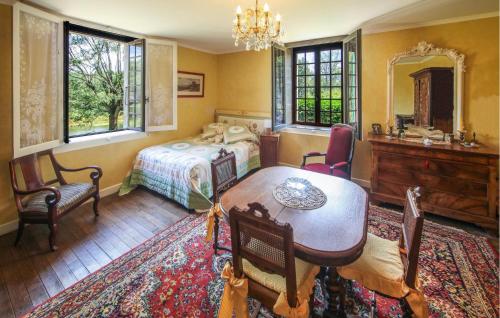 Schlafzimmer mit einem Bett, einem Tisch und Stühlen in der Unterkunft Awesome Home In Chemilly With House Sea View 