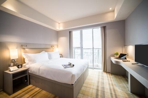 um quarto de hotel com uma cama grande e uma janela em One Dundas em Hong Kong