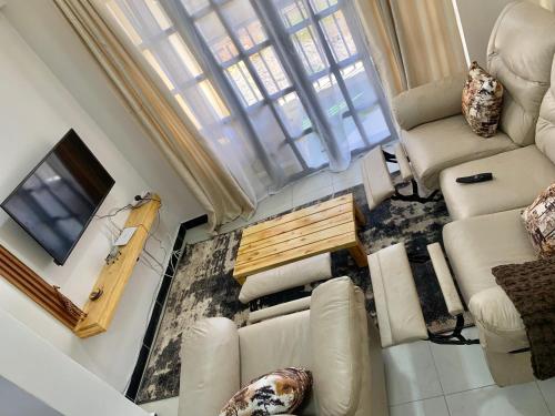 ein Wohnzimmer mit Sofa und TV in der Unterkunft Rorot 1 bedroom Modern fully furnished space in Annex Eldoret with free wifi in Eldoret