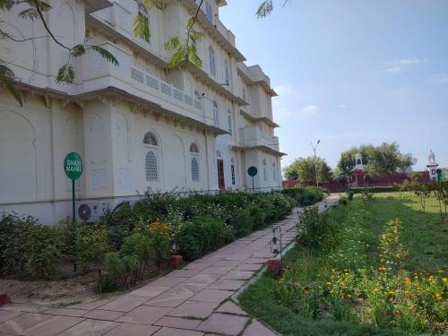 een gebouw met een bloementuin ervoor bij Aaram Baagh Agra in Agra