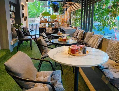 a room with tables and chairs with food on them at To Bed Poshtel in Chiang Mai