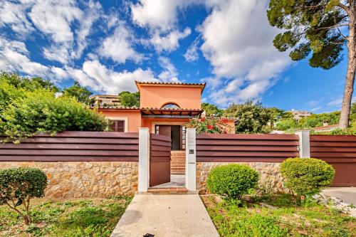 een huis met een poort en een muur bij Beach Villa Margot in Port de Pollença