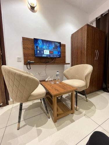 a living room with two chairs and a table and a tv at Hotel platinum inn in Ludhiana