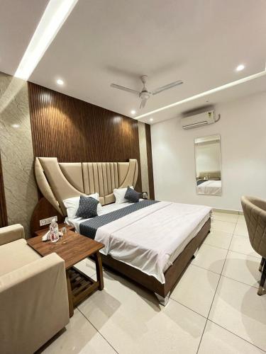 a bedroom with a bed and a table and a couch at THE LUXURY PLATINUM INN --Luxury Deluxe Rooms -- Chandigarh Road in Ludhiana