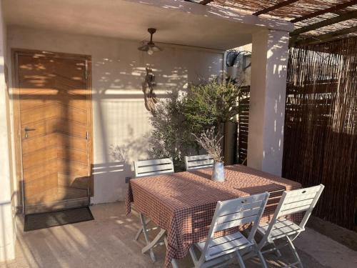 une table et des chaises assises sur une terrasse dans l'établissement Maison de village cosy et chaleureuse, à Tavera