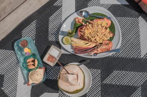 a table with two plates of food and a drink at De Chaochom Hua Hin in Hua Hin