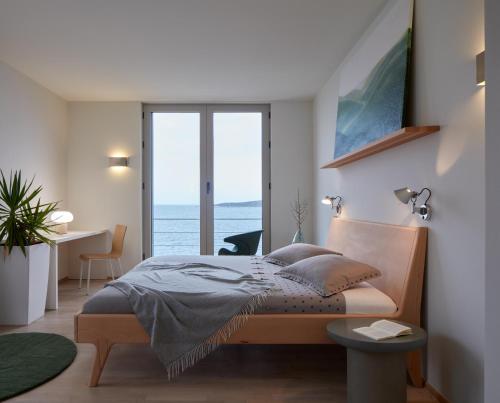 a bedroom with a bed with a view of the ocean at Villa Roca in Vis