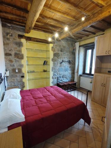 a bedroom with a large red bed in a building at Dimora de' Canulei in Bolsena