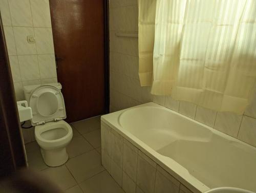 a bathroom with a toilet and a bath tub at Home in kigali in Kigali