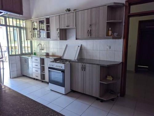 a kitchen with wooden cabinets and a stove at Home in kigali in Kigali