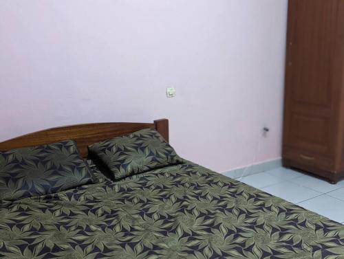 a bed with two pillows on it in a bedroom at Home in kigali in Kigali