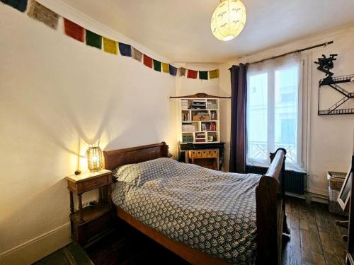 une chambre avec un lit et une fenêtre dans l'établissement Charming 2-room apartment with garden - 10 min from the centre of Paris and the Olympic Village, à Saint-Denis