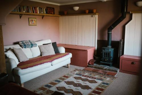 un soggiorno con divano e stufa a legna. di Whichford Mill Barn- Soulful retreat. a Shipston-on-Stour