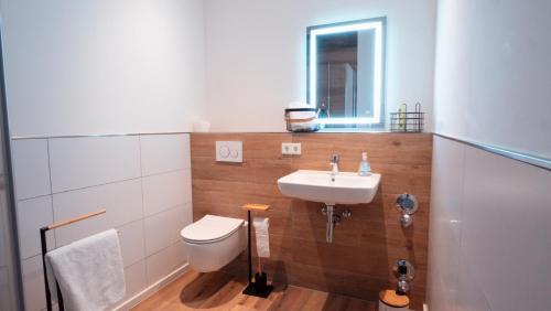 a bathroom with a white toilet and a sink at Wohnen auf Zeit in Saarbrücken in Saarbrücken