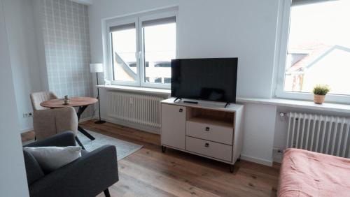 a living room with a flat screen tv on a dresser at Wohnen auf Zeit in Saarbrücken in Saarbrücken