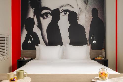 a bedroom with a bed with a poster of two eyes at The Manor Amsterdam in Amsterdam