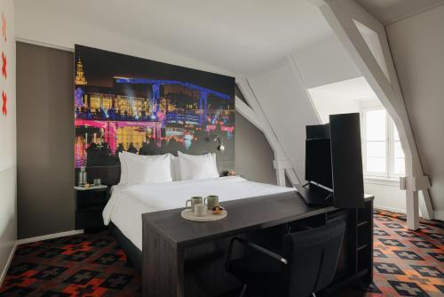 um quarto de hotel com uma cama e uma televisão em The Manor Amsterdam em Amsterdã