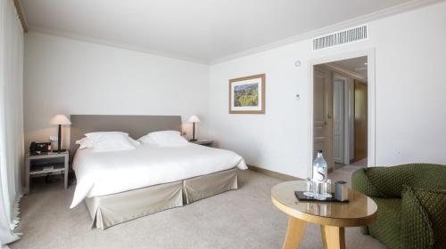 a bedroom with a bed and a couch and a table at La Villa Calvi in Calvi