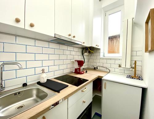 a kitchen with white cabinets and a sink at Green House Studios in Braşov