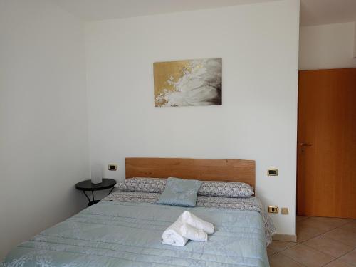 una camera da letto con un letto e asciugamani di Da Eolo - Appartamento al mare a Grottammare