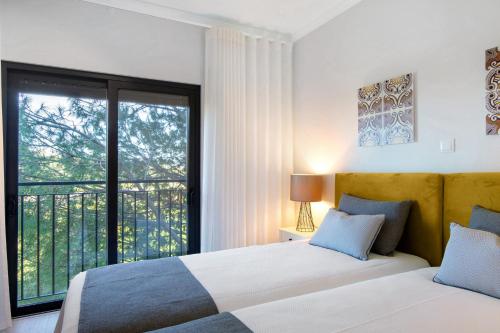 a bedroom with two beds and a large window at Apartamento Beira Mar - 1º Direito in Tavira