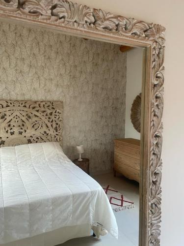 a bedroom with a white bed and a mirror at Villa Dolce Valle in Ragusa