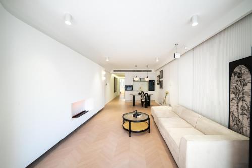 a living room with a white couch and a table at Shanghai Downtown Yi Du B&B - Near Hongqiao Station and Jiaotong University in Shanghai