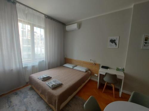 una piccola camera da letto con un letto e una scrivania di Studio 72 a Sofia