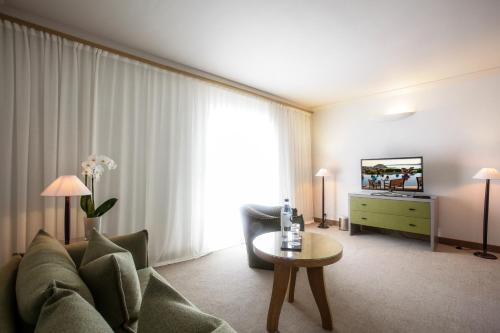 a living room with a couch and a tv at La Villa Calvi in Calvi