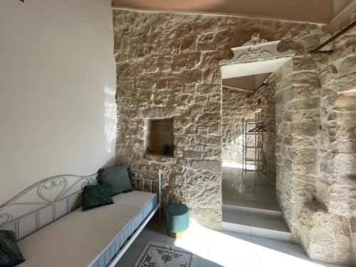 um quarto com um sofá contra uma parede de pedra em Villa Dolce Valle em Ragusa