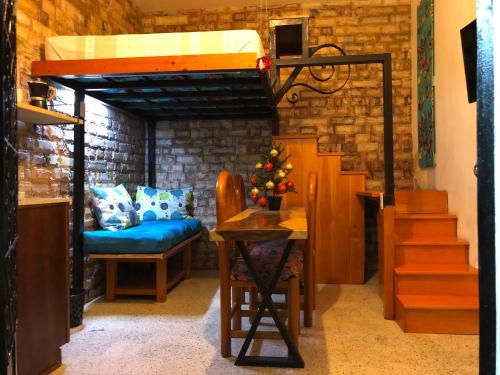 a room with a bunk bed and a table with a christmas tree at Casita La Adornada in Taxco de Alarcón