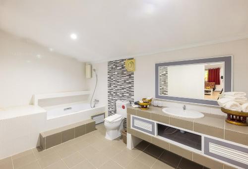 ein Badezimmer mit einer Badewanne, einem WC und einem Waschbecken in der Unterkunft Silamanee Resort & Spa Hotel in Mae Sai