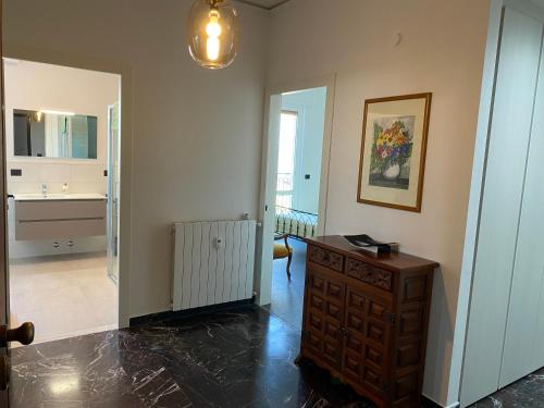 a room with a hallway with a dresser and a kitchen at Spazioso Attico fronte mare Albenga in Albenga