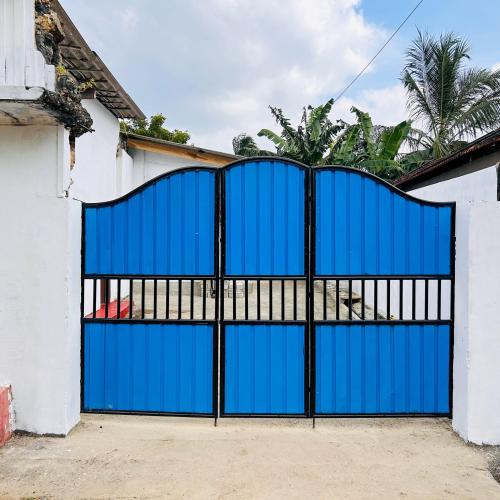 a blue gate in a white house at Nithusha holiday house நிதுஷா சுற்றுலா விடுதி+94 74 241 7475 whatsapp in Jaffna