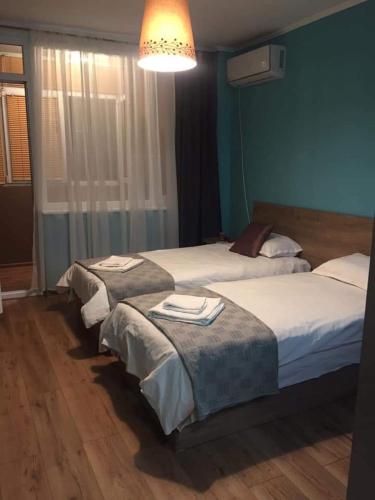 three beds in a bedroom with a blue wall at Center in Shumen