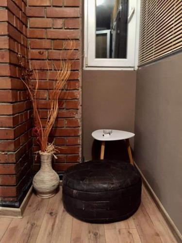 a room with a table and a tire next to a brick wall at Center in Shumen