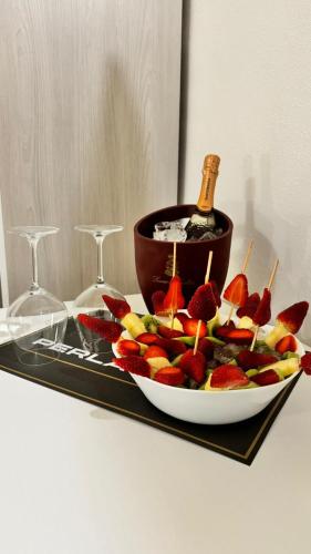 a plate of fruit with a bottle of wine and glasses at Perla Suite in Mesagne