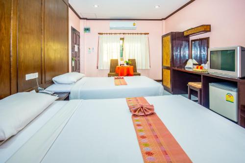 ein Hotelzimmer mit 3 Betten und einem TV in der Unterkunft Silamanee Resort & Spa Hotel in Mae Sai