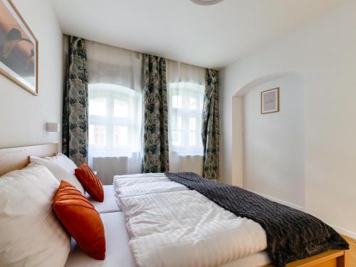 a bedroom with a bed with pillows and a window at Hviezdoslavova Apartments, Trnava Centre, Parking available in Trnava