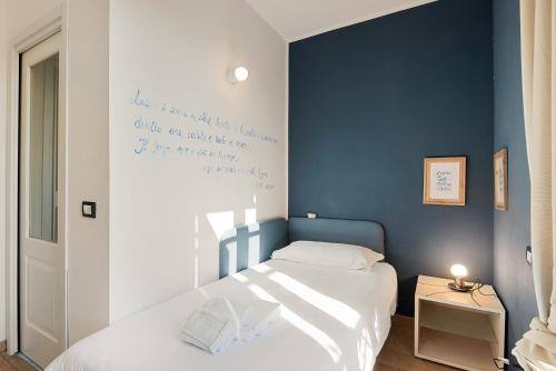 1 dormitorio con 2 camas y pared azul en Accogliente camera singola con balcone a 500 mt dal mare en Marina di Carrara