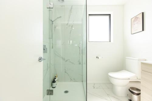 a bathroom with a shower and a toilet at Modern 2 bedroom by Hagley Park in Christchurch