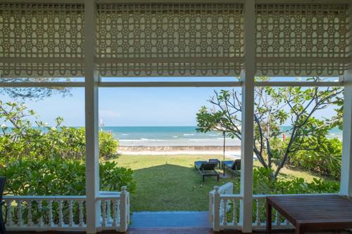 a screened in porch with a view of the ocean at De Chaochom Hua Hin in Hua Hin