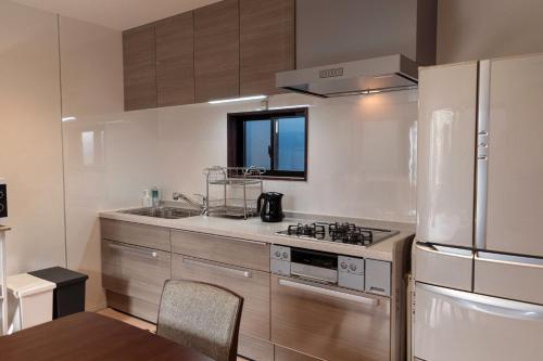 a kitchen with a stove and a refrigerator at Ittokashivacationrental nuevoL7 - Vacation STAY 83674v in Numata