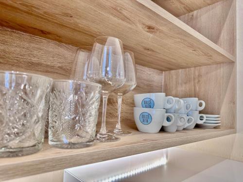 a shelf with wine glasses and cups on it at City life Arsenale in Verona